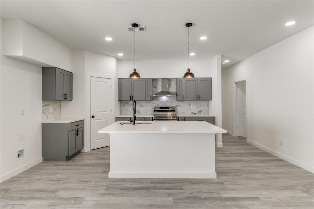 3108 Delafield Lane Dallas, TX 75227 - Photo 13 of 30 a view of kitchen with stainless steel appliances kitchen island a sink a stove and a wooden floors