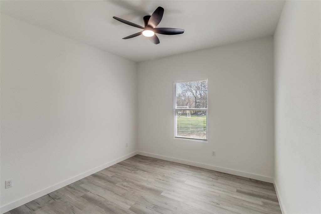 3108 Delafield Lane Dallas, TX 75227 - Photo 26 of 30 an empty room with a window and a ceiling fan