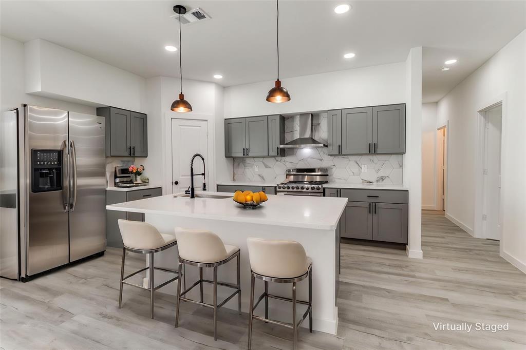 3108 Delafield Lane Dallas, TX 75227 - Photo 6 of 30 a kitchen with stainless steel appliances a table chairs refrigerator and microwave