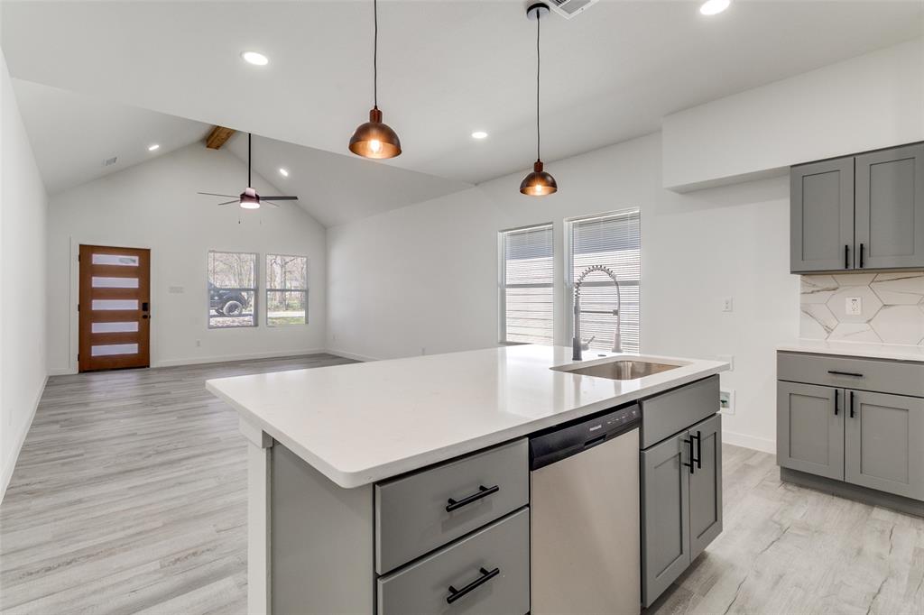 3108 Delafield Lane Dallas, TX 75227 - Photo 8 of 30 a kitchen with a stove center island a wooden floor and white cabinets