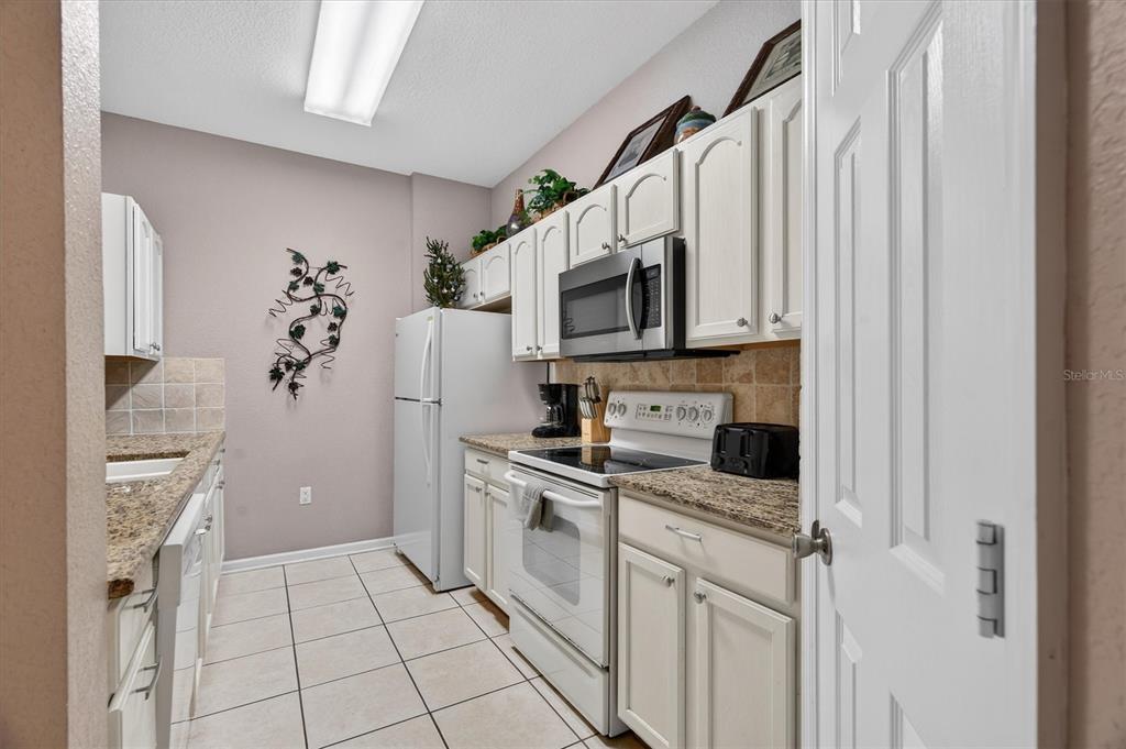 7664 Comrow Street, Unit 304 Kissimmee, FL 34747 - Photo 11 of 42 a kitchen with stainless steel appliances a refrigerator sink and microwave