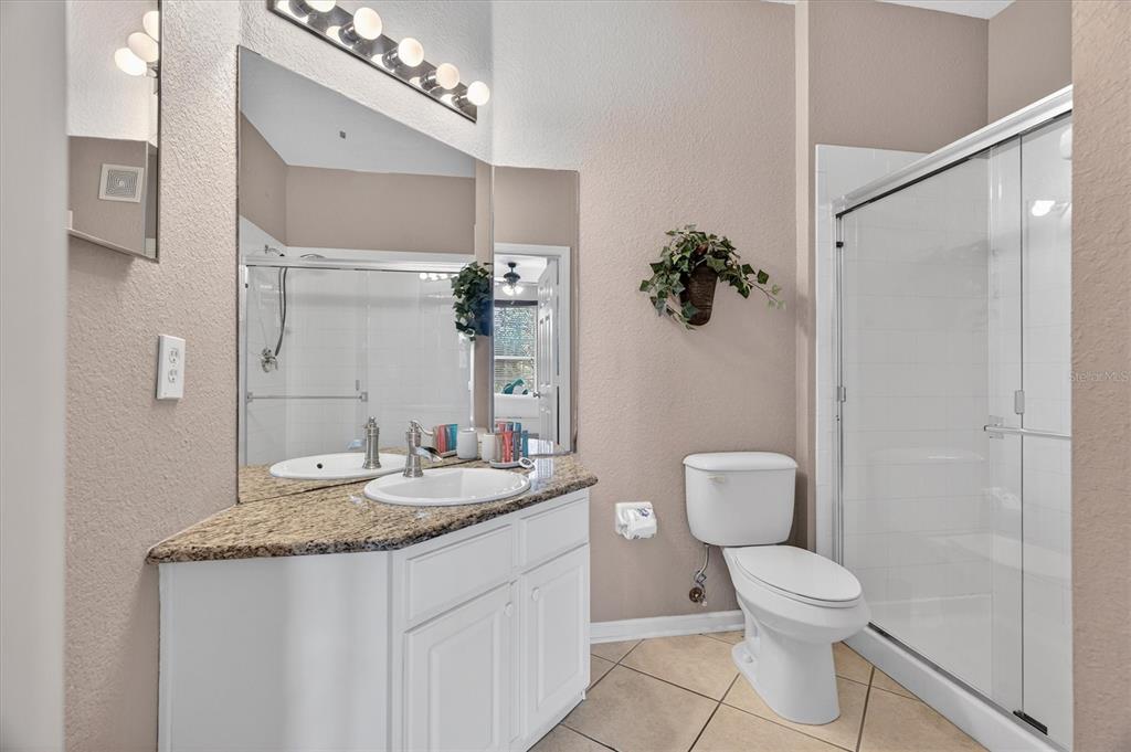 7664 Comrow Street, Unit 304 Kissimmee, FL 34747 - Photo 15 of 42 a bathroom with a granite countertop sink a toilet and a mirror