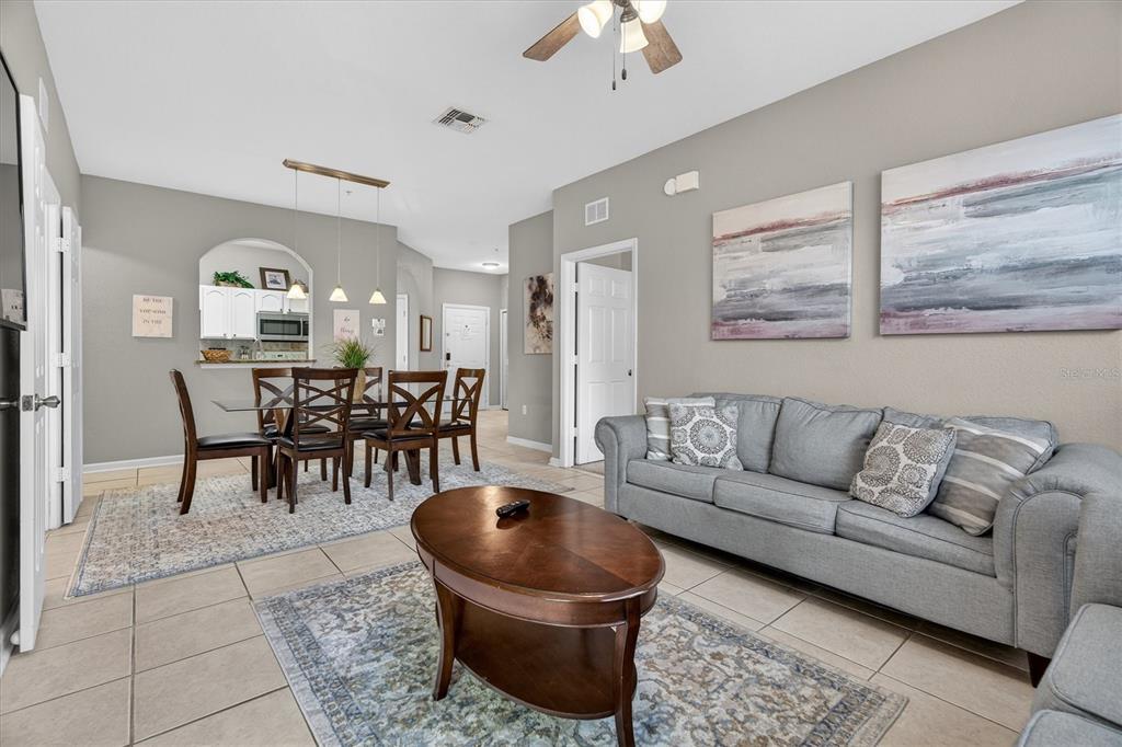 7664 Comrow Street, Unit 304 Kissimmee, FL 34747 - Photo 5 of 42 a living room with furniture a rug and a chandelier