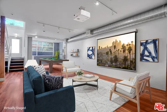 a living room with furniture a flat screen tv and a large window