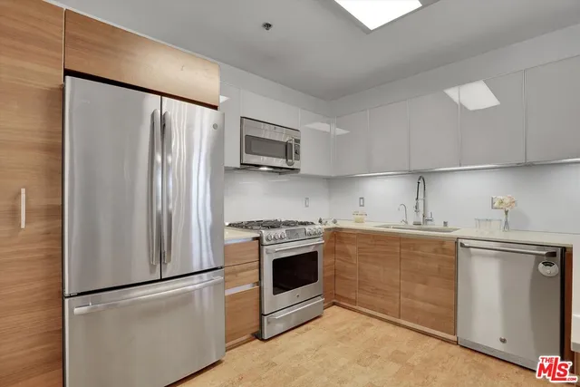 a kitchen with stainless steel appliances a refrigerator sink and microwave