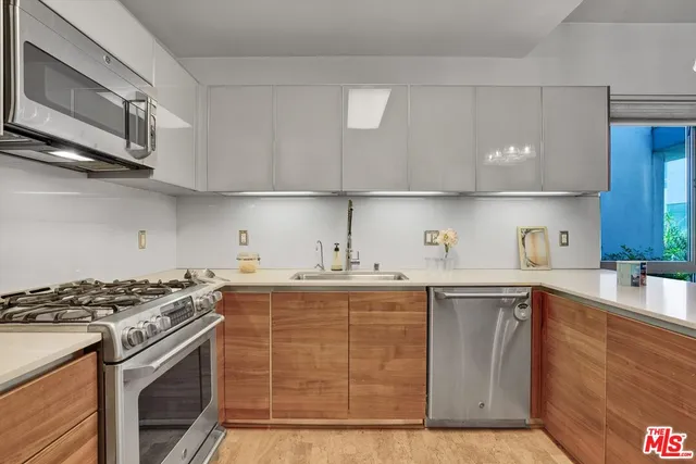 a kitchen with stainless steel appliances granite countertop a sink stove and cabinets