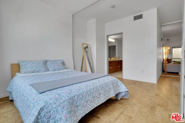 a bedroom with a bed and a view of living room