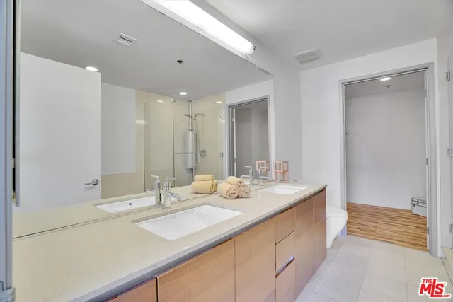 a bathroom with double vanity sinks and a mirror