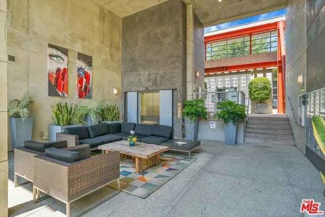 a living room with patio furniture and a potted plant