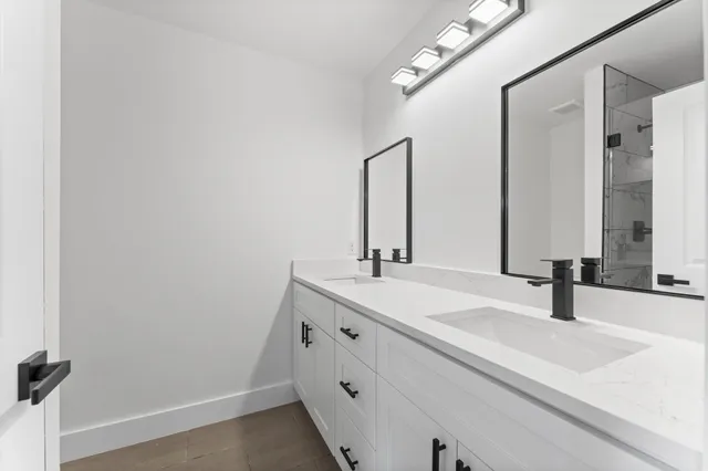 a bathroom with a double vanity sink and a mirror