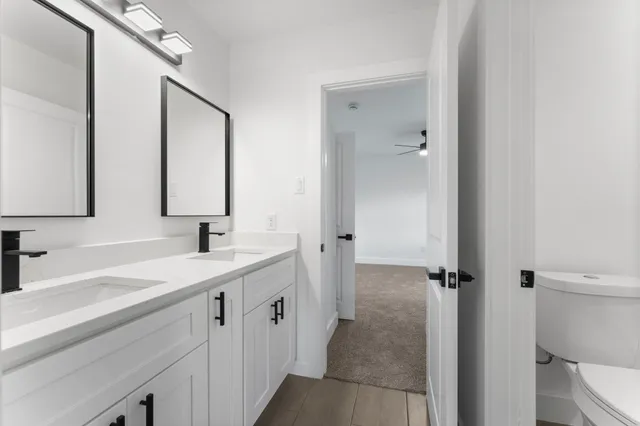 a bathroom with a sink and mirror with toilet