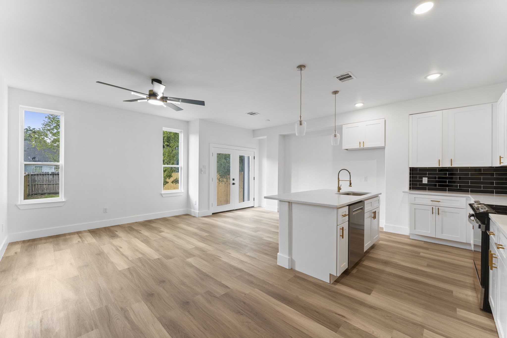 8205 Carver Road Houston, TX 77088 - Photo 9 of 37 a kitchen with granite countertop a stove a sink and white cabinets with wooden floor