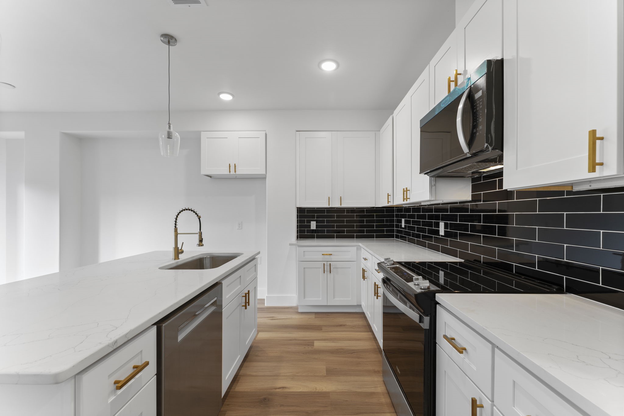 8205 Carver Road Houston, TX 77088 - Photo 10 of 37 a kitchen with a sink and a stove top oven with wooden floor