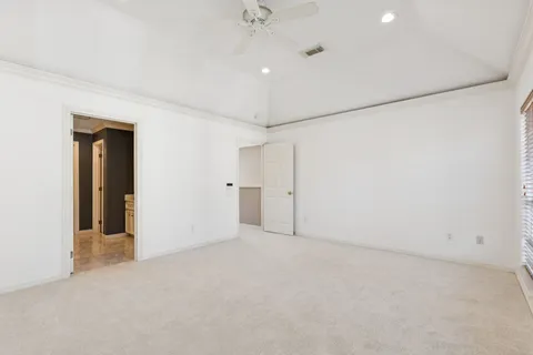 an empty room with a ceiling fan and a window