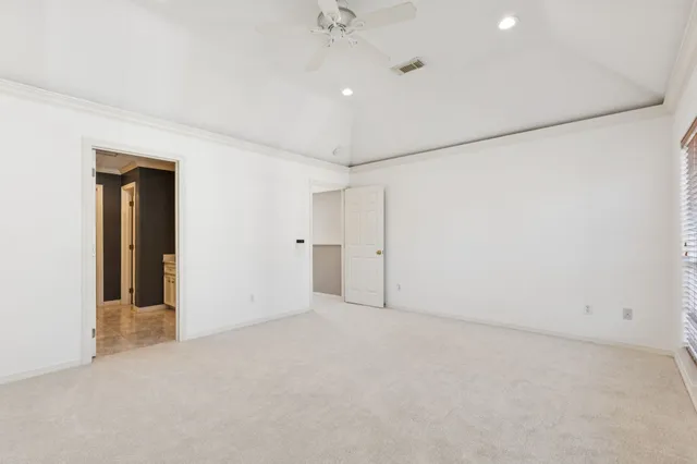 an empty room with a ceiling fan and a window