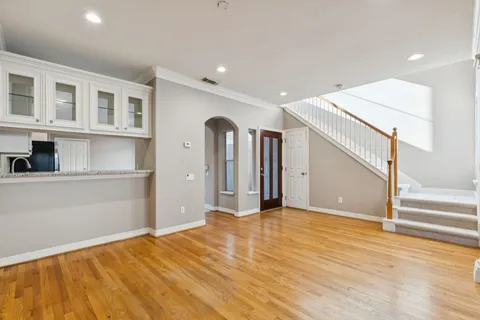 a view of an empty room with wooden floor and a cabinet