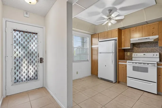 a kitchen with white cabinets and white appliances