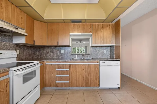 a kitchen with cabinets appliances a sink and a counter top space