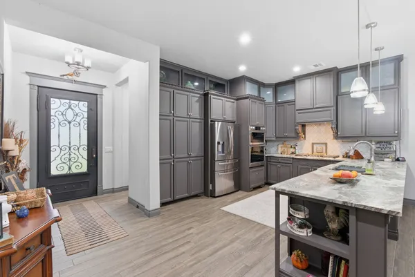 a kitchen with stainless steel appliances a refrigerator and a stove top oven