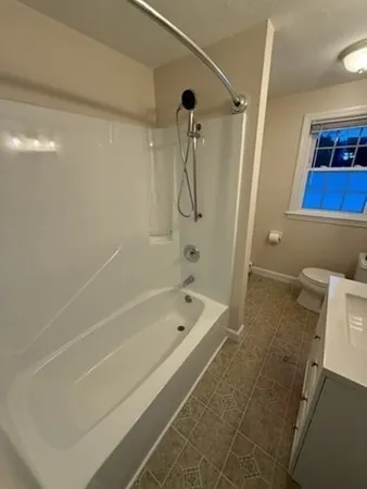 a bathroom with a shower a bath tub and a shower