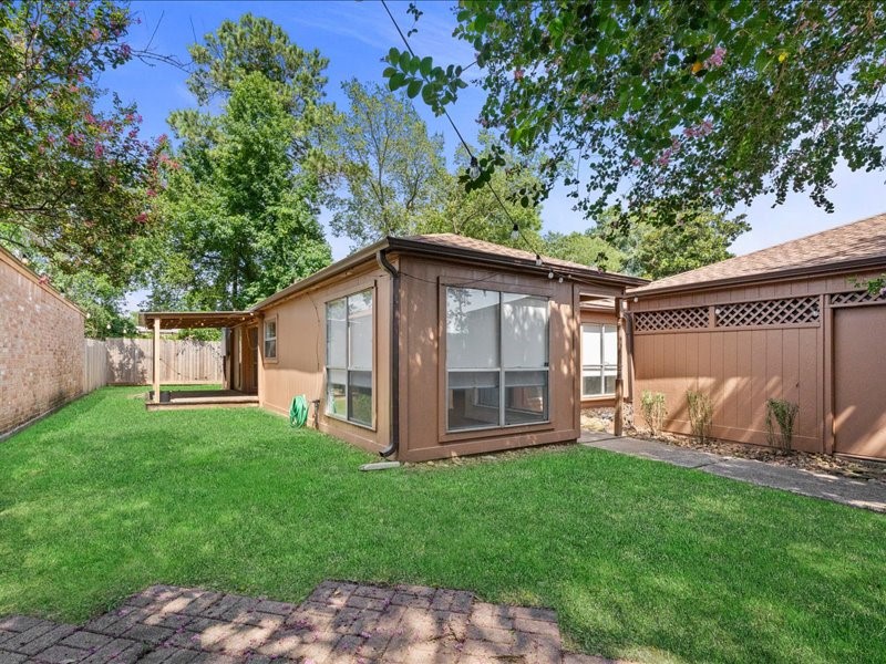 6631 Ambler Drive Spring, TX 77379 - Photo 33 of 37 a view of a backyard with table and chairs and a large tree