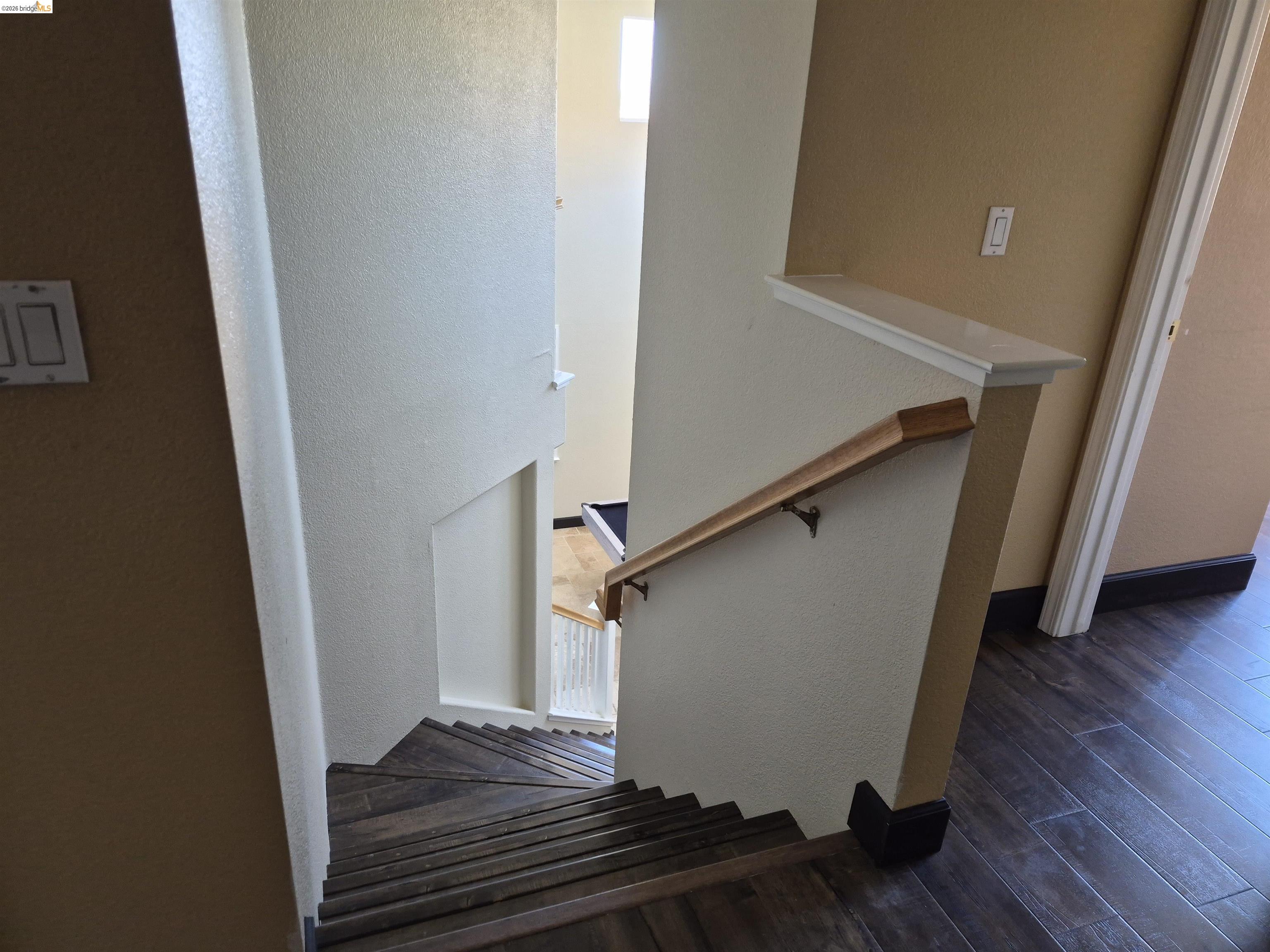149 Oakpoint Court Bay Point, CA 94565 - Photo 10 of 22 Stairwell featuring wood-finish treads, a contrasting wood handrail, and a half-wall with a display ledge