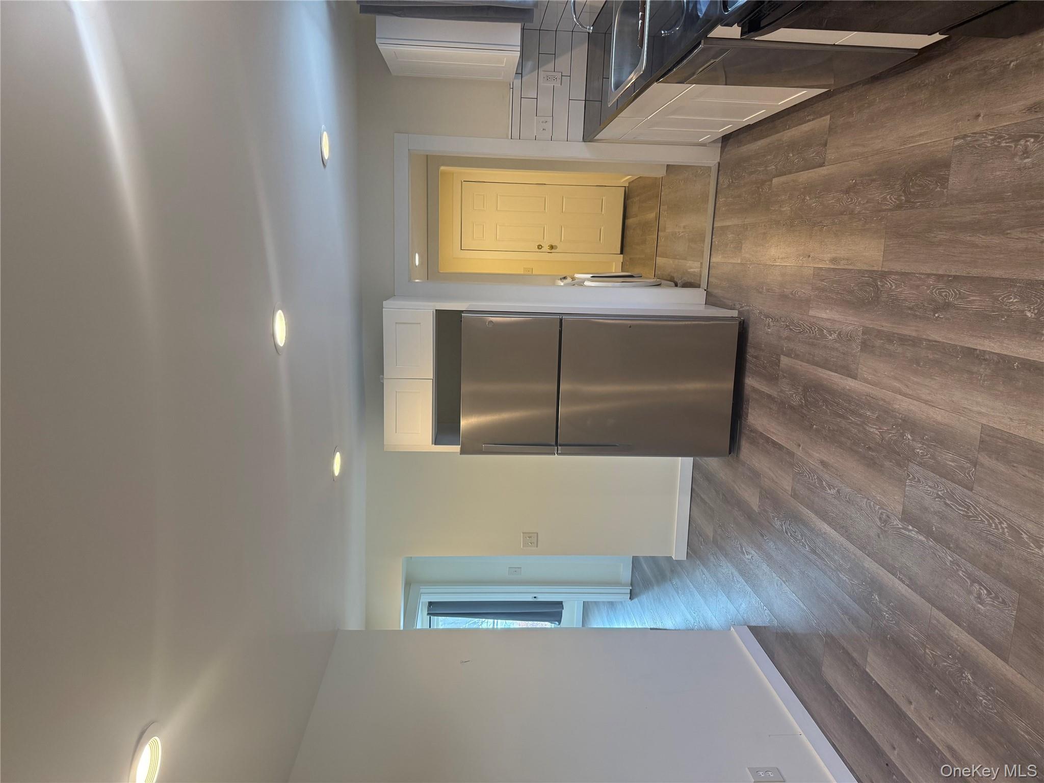 92 Wigsten Road, Unit 1 Pleasant Valley, NY 12569 - Photo 3 of 8 a view of a kitchen with a wooden floor and stainless steel appliances