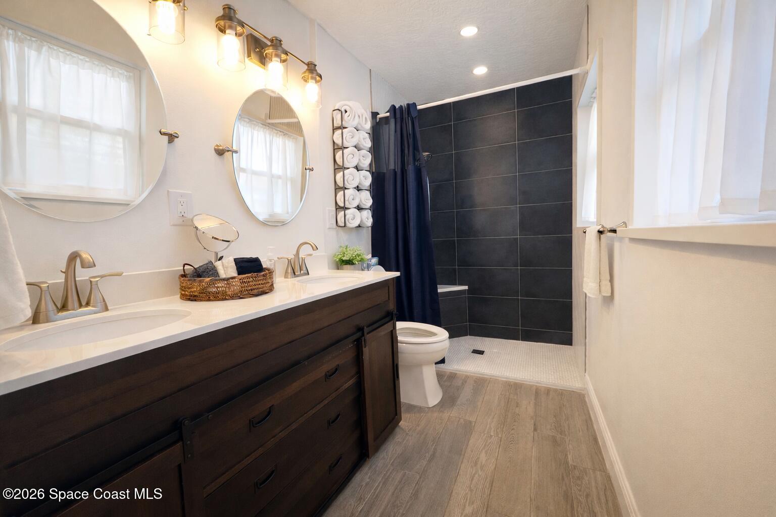 120 Boca Ciega Road Cocoa Beach, FL 32931 - Photo 11 of 23 a bathroom with a sink a toilet a mirror and shower