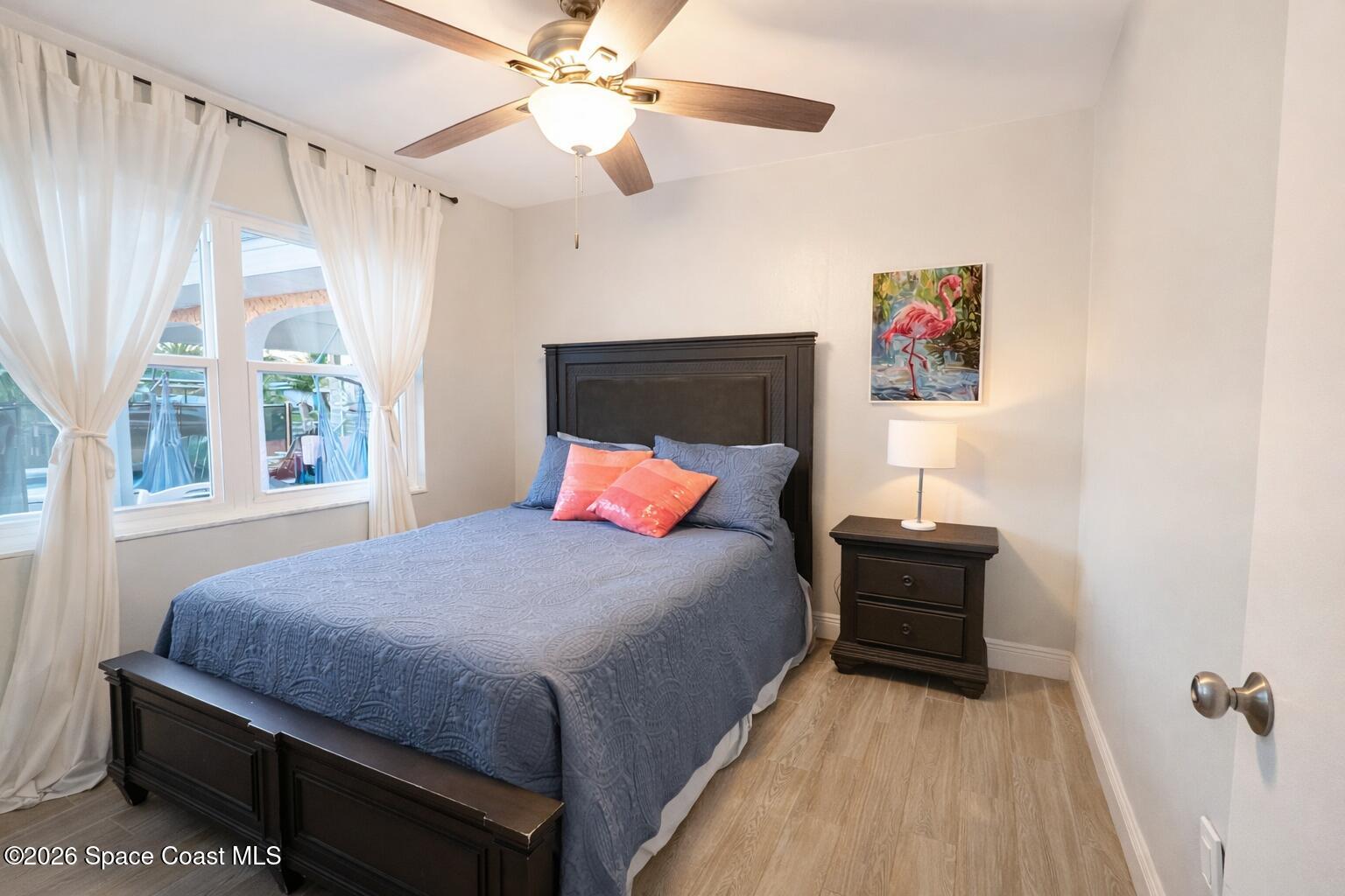 120 Boca Ciega Road Cocoa Beach, FL 32931 - Photo 12 of 23 a bedroom with a bed and a chandelier