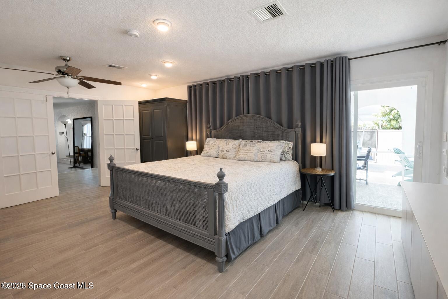 120 Boca Ciega Road Cocoa Beach, FL 32931 - Photo 17 of 23 a large bedroom with a bed and a wooden floor