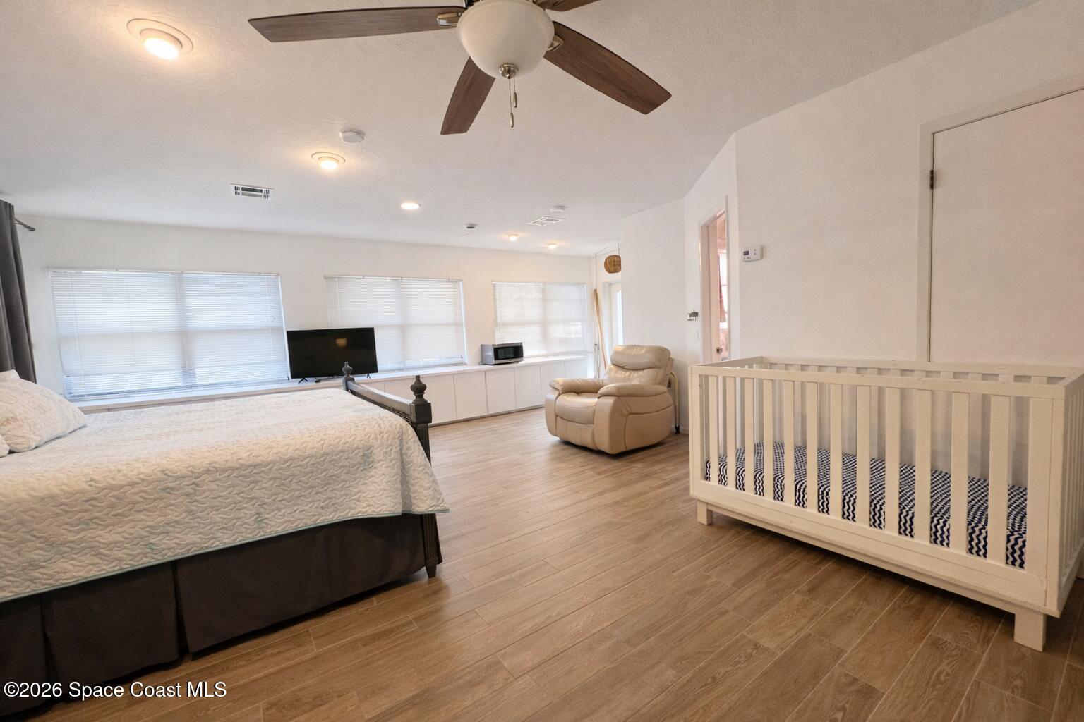 120 Boca Ciega Road Cocoa Beach, FL 32931 - Photo 18 of 23 a spacious bedroom with a bed and a chandelier