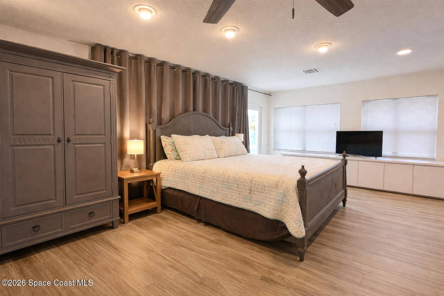 120 Boca Ciega Road Cocoa Beach, FL 32931 - Photo 19 of 23 a large bedroom with a bed and wooden floor