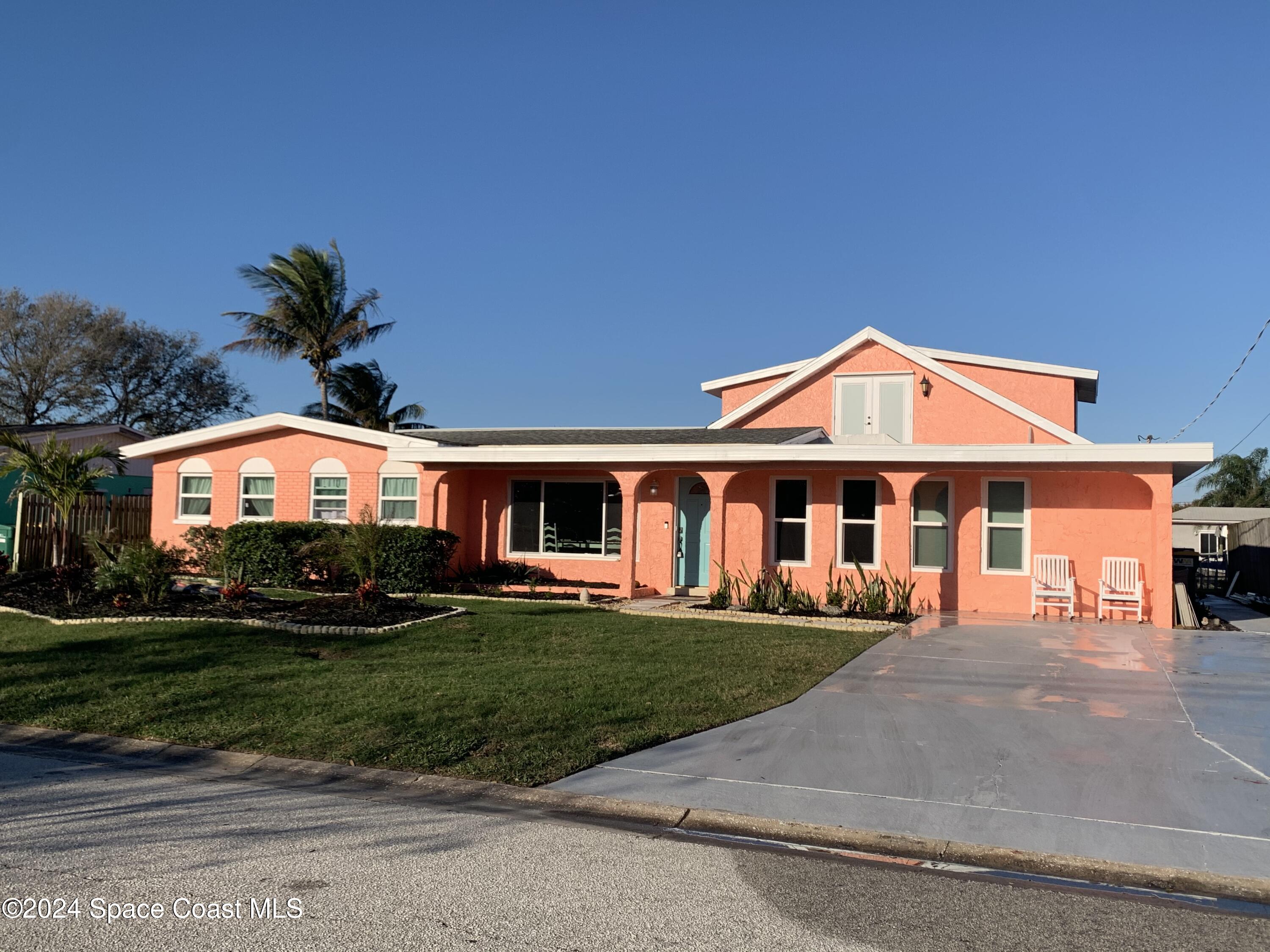 120 Boca Ciega Road Cocoa Beach, FL 32931 - Photo 2 of 23 a front view of a house with a yard