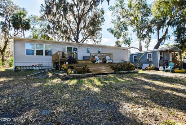 a view of a house with a large tree in a yard