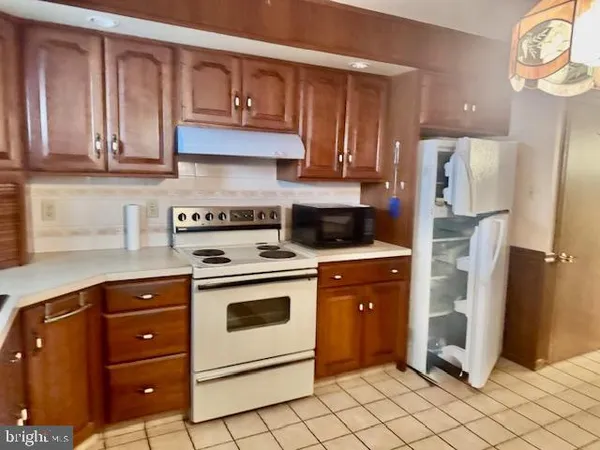 a kitchen with stainless steel appliances granite countertop a refrigerator a stove and a sink