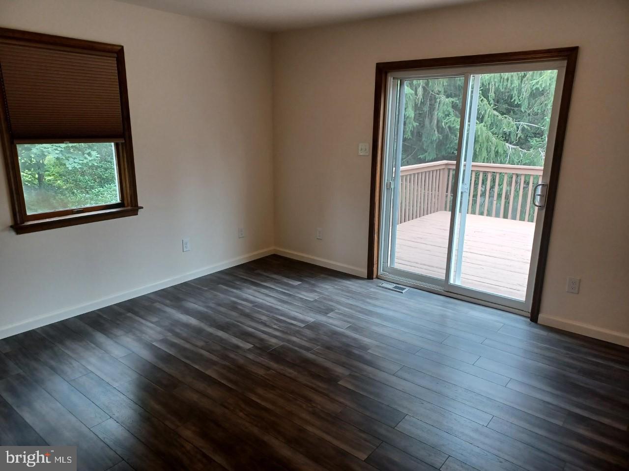 1525 Yardley Newtown Road, Unit 1 Morrisville, PA 19067 - Photo 7 of 14 a view of an empty room with wooden floor and a window