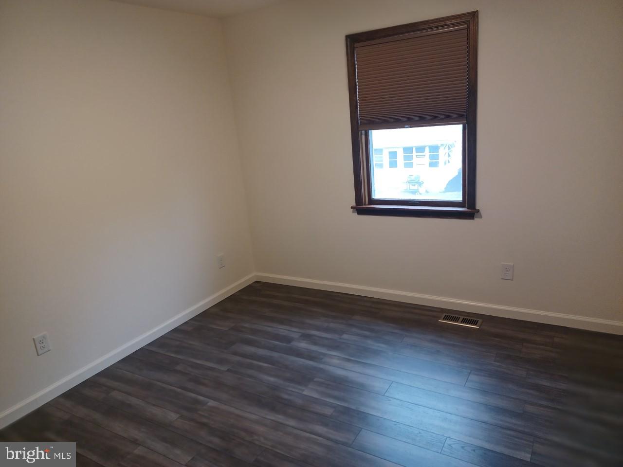1525 Yardley Newtown Road, Unit 1 Morrisville, PA 19067 - Photo 8 of 14 an empty room with wooden floor and windows