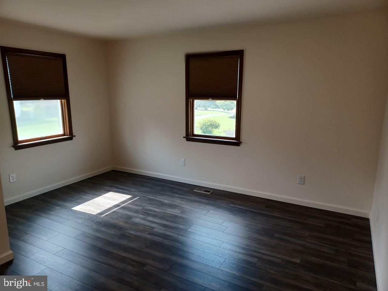 1525 Yardley Newtown Road, Unit 1 Morrisville, PA 19067 - Photo 9 of 14 an empty room with wooden floor and windows