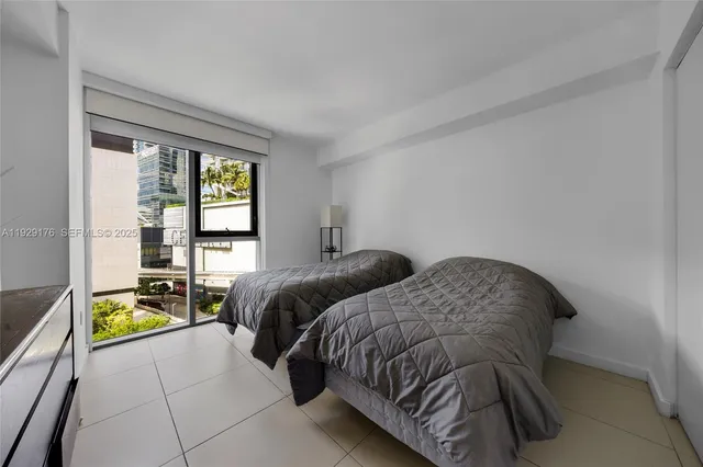 a bedroom with two beds and a window