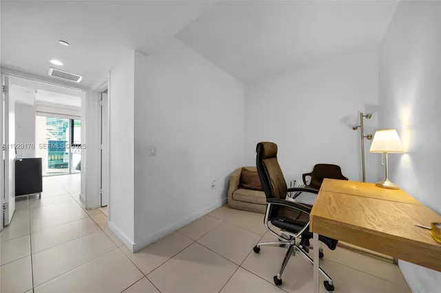 a view of a workspace with furniture and a bathroom
