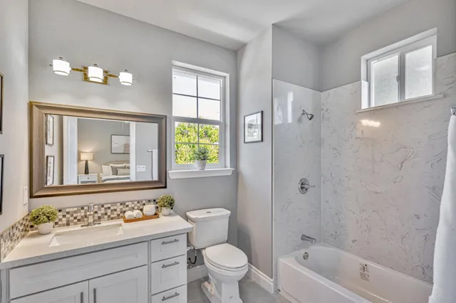 a bathroom with a sink a toilet a shower a mirror and a bathtub