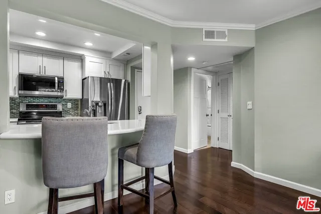 a kitchen with stainless steel appliances granite countertop a refrigerator a stove a microwave a sink and a refrigerator