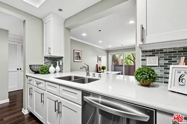 a kitchen with kitchen island a potted plant and white cabinets