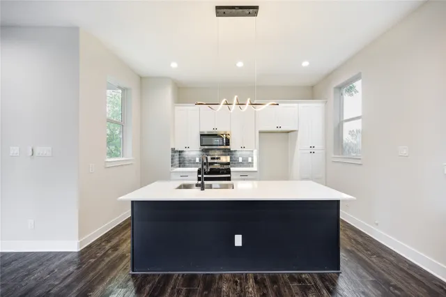 a kitchen with kitchen island a sink stove and refrigerator
