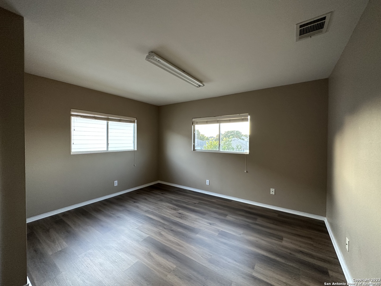 8019 Rio NIEBLA San Antonio, TX 78249 - Photo 11 of 16 a view of an empty room with wooden floor and a window