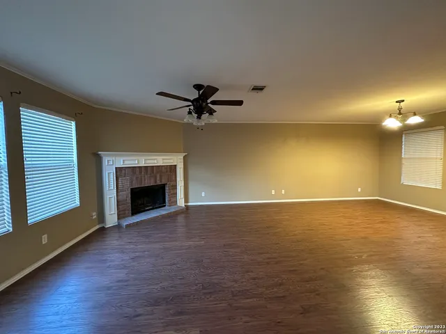 a view of an empty room with glass door and wooden floor