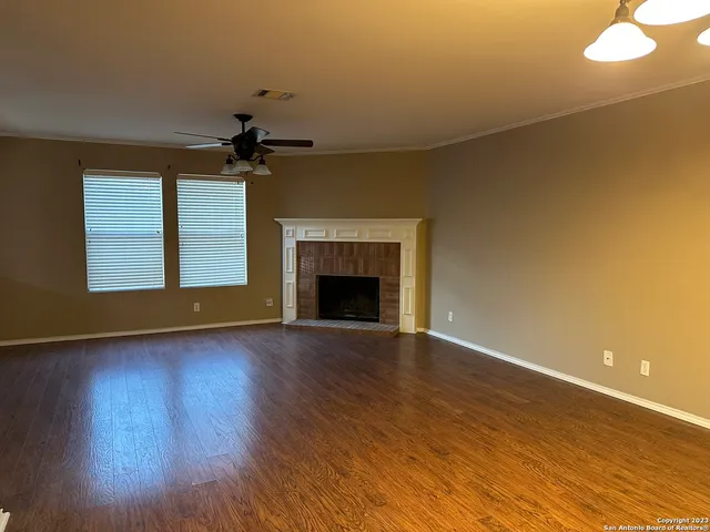 a view of an empty room with a fireplace and a window