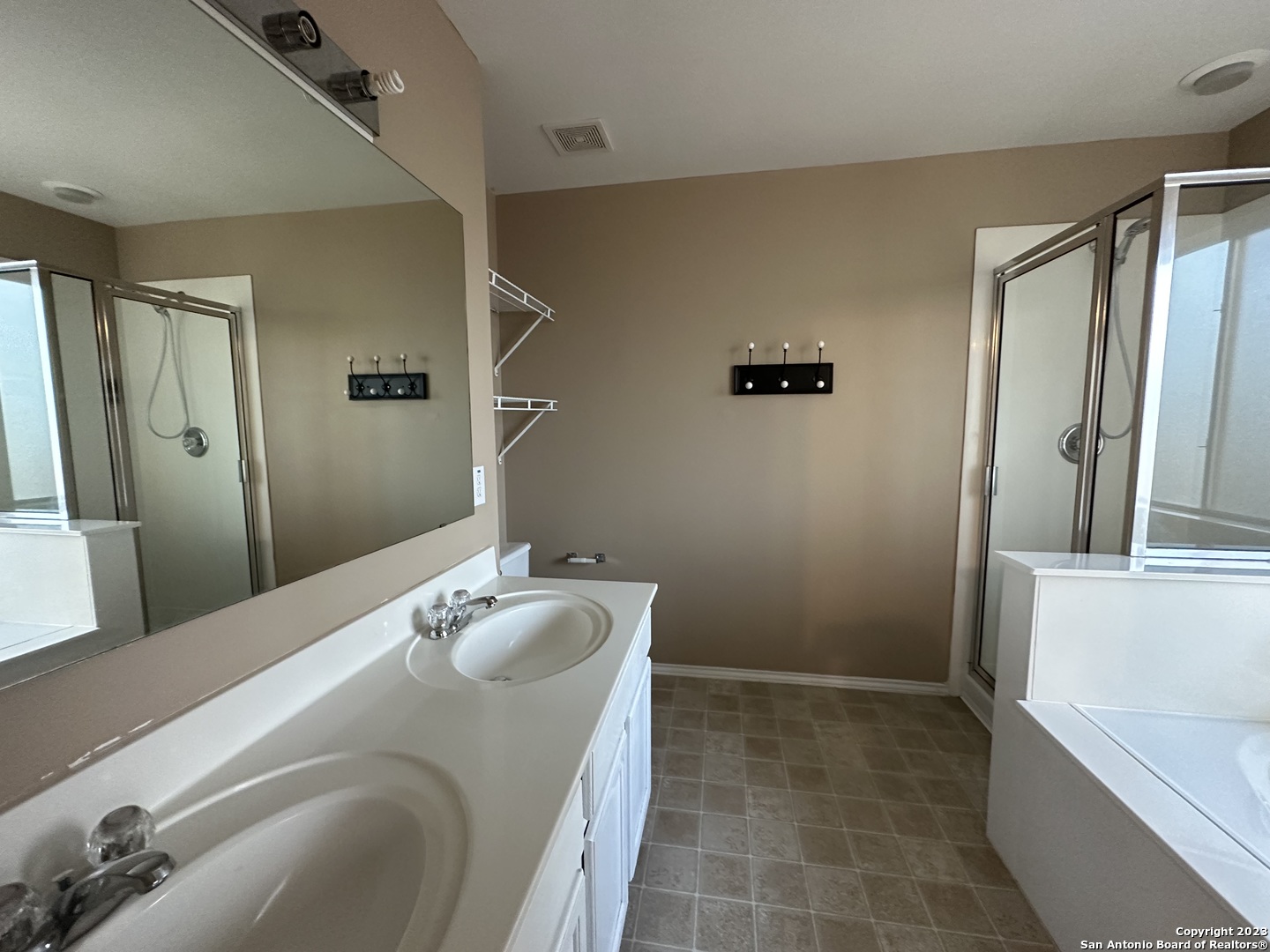 8019 Rio NIEBLA San Antonio, TX 78249 - Photo 10 of 16 a bathroom with a granite countertop sink a mirror and a bathtub