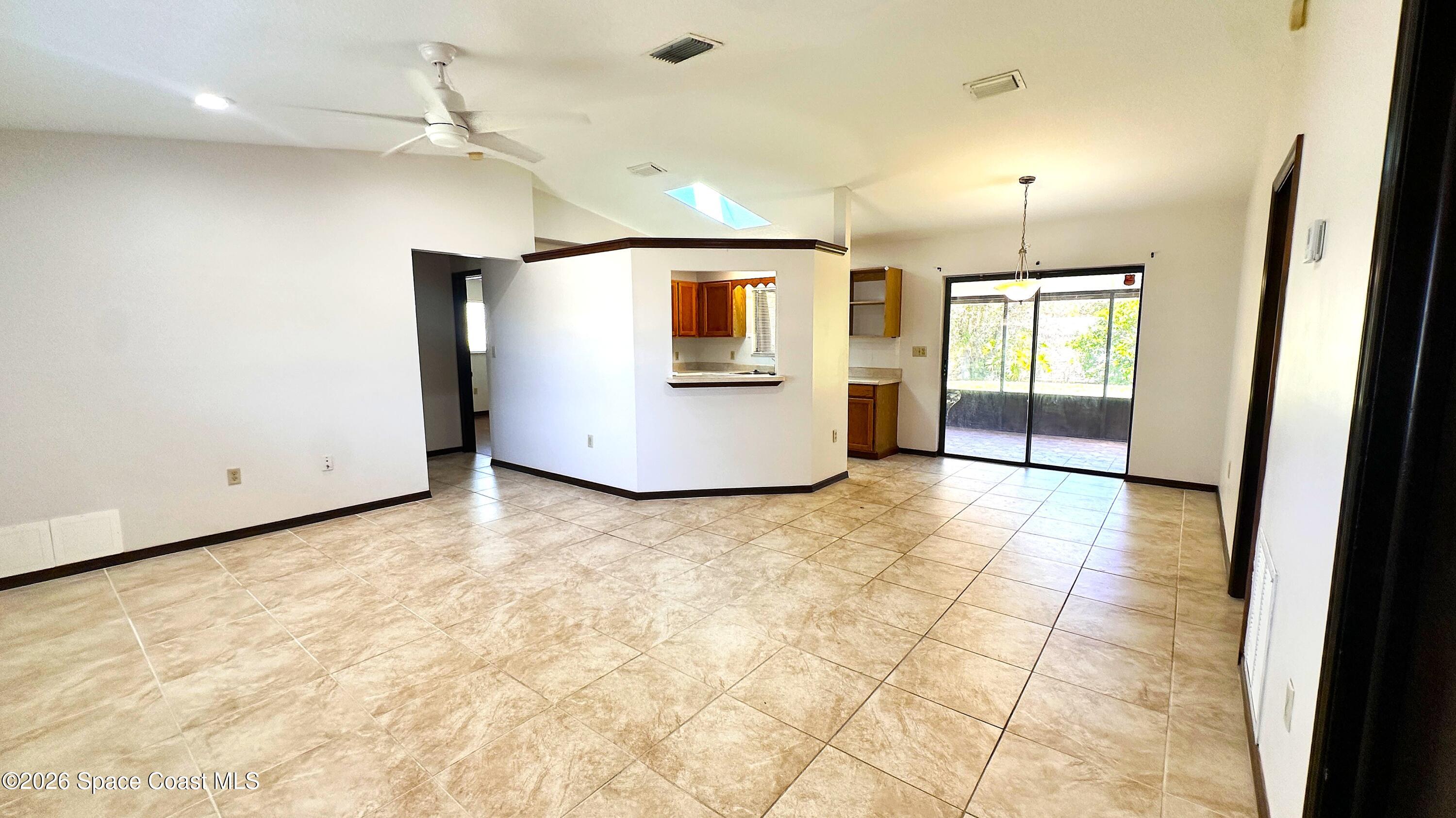 931 Commerce Road Southeast Palm Bay, FL 32909 - Photo 2 of 19 a view of an empty room with wooden floor and a window