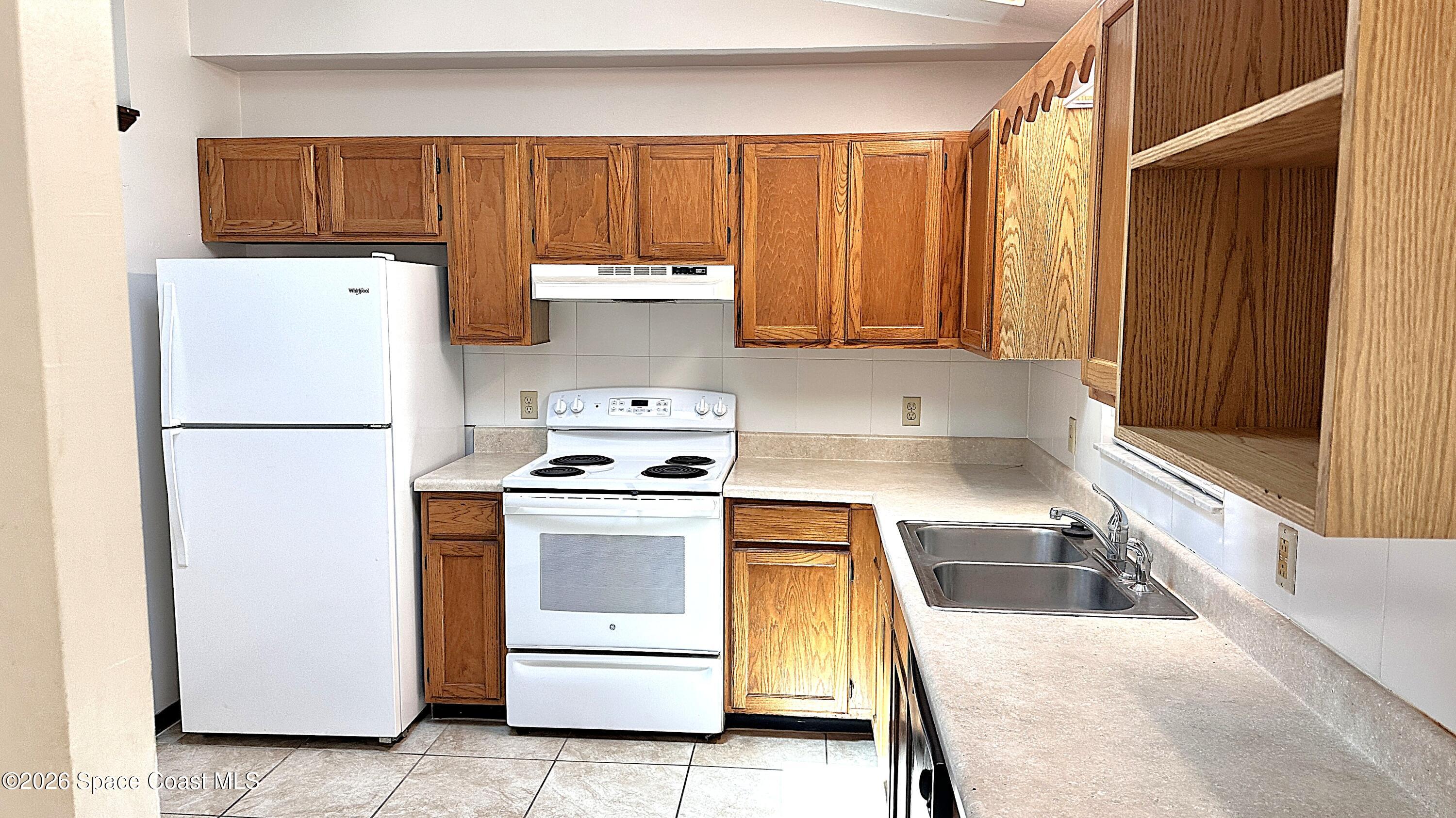 931 Commerce Road Southeast Palm Bay, FL 32909 - Photo 5 of 19 a kitchen with a white cabinets and white appliances